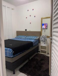 a bedroom with a bed and a mirror and a fan at proximo aos principais pontos de bc in Camboriú