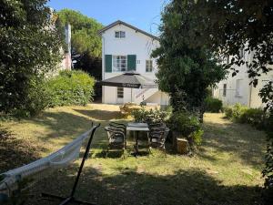 a table and chairs in front of a house at Maison bord de mer - 11 personnes in La Baule +7 photos