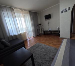 a living room with a couch and a television at 1 кімнатна квартира in Novomoskovsʼk