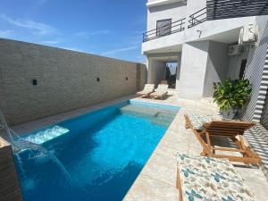 a swimming pool in the backyard of a house at Villa Nafissa in Diass