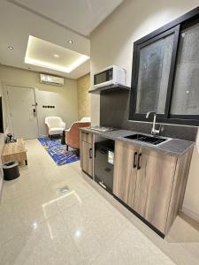 - une cuisine avec évier et four micro-ondes dans l'établissement XYZ Hotel Qurtoba, à Riyad