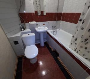 a bathroom with a toilet and a sink and a tub at 1 кімнатна квартира in Novomoskovsʼk