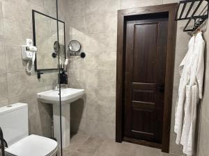 a bathroom with a toilet and a sink and a mirror at Grand Way Hotel in Taraz