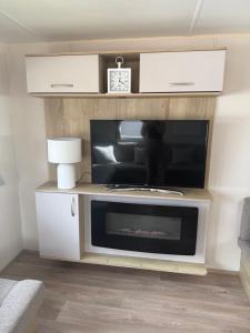 a living room with a fireplace and a tv at Tattershall lakes country park The Fairways in Tattershall