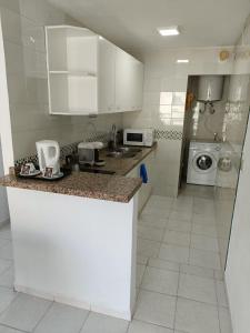 トレモリノスにあるApartamentos Playa Bajondilloの白いキャビネットとカウンタートップを備えたキッチン
