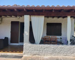 a porch of a house with a table and chairs at Bougainville Bianco in Quartu SantʼElena