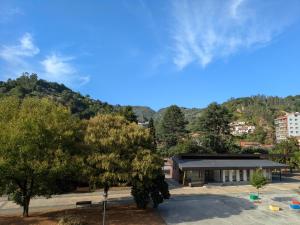a building in a park with trees and a mountain at Precioso apartamento en el Paraíso Natural 