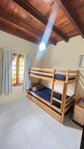 ein Schlafzimmer mit Etagenbetten in einem Zimmer mit Holzdecken in der Unterkunft Condomínio Village do Araripe - Casa Brisa da Serra in Gravatá