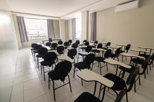 a room full of desks and chairs in a classroom at Honorato Hotel by Easy Hotéis in Rio Verde
