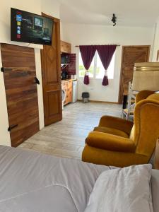 a bedroom with a bed and a tv and a couch at La Puertita de Acantilados in Mar del Plata