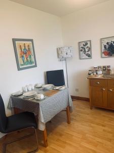 a dining room with a table with plates on it at Mo-Dhachaidh B&B in Poolewe