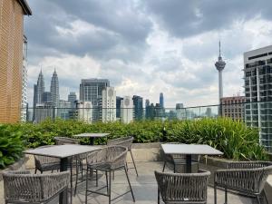 a patio with tables and chairs and a view of the city at MAJESTIC RESlDENCE KLCC in Kuala Lumpur