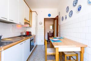 a kitchen with white cabinets and a wooden table at Santa Margherita Center - Steps from the Sea - AC in Santa Margherita Ligure