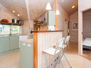 a kitchen with chairs and a counter in a tiny house at holiday home in Fårvang
