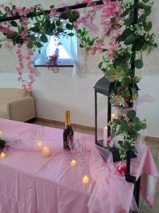 una mesa con copas de vino, velas y flores en Oasi di san Benedetto, en Castellaneta