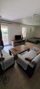 a living room with two beds and a tv at Logement entier chez Hélène in Sainte-Gemme-Martaillac