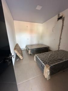 - 2 lits dans une chambre avec une porte ouverte dans l'établissement Rancho Fiel - Lago das Brisas, à Burity Alegre