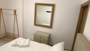 a bedroom with a bed and a mirror on the wall at Rhodes Beach Side Houses in Ixia +3 photos