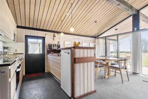 een keuken en eetkamer met een tafel en stoelen bij 0321-Romo-Stormengevej-4 in Mølby +14 foto's