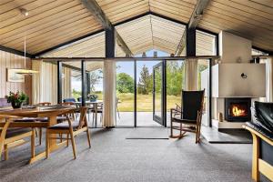 een eetkamer met een tafel en een open haard bij 0321-Romo-Stormengevej-4 in Mølby