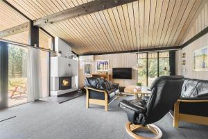 een woonkamer met lederen meubels en een open haard bij 0321-Romo-Stormengevej-4 in Mølby