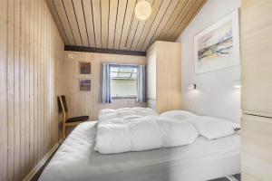 een slaapkamer met 4 bedden en witte lakens bij 0321-Romo-Stormengevej-4 in Mølby