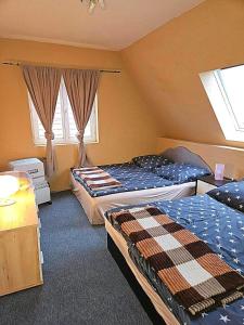 une chambre avec deux lits et deux fenêtres dans l'établissement whole house, à Budapest