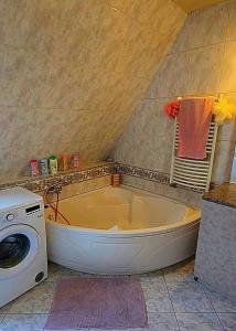 une salle de bain avec baignoire et machine à laver dans l'établissement whole house, à Budapest