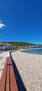 a bench on a beach near the water at House Roko and Karla in Kali