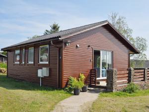 a small wooden cabin with a large window at Hawthorne in Woolfardisworthy +1 photo