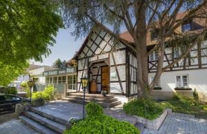 ユーバーリンゲンにあるロマンティック ホテル ヨハンニッター クラウスの前に木がある家