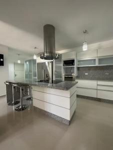 a kitchen with white cabinets and a black counter top at Casa de la Bondad in El Hato +14 photos