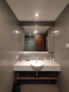a bathroom with a white sink and a mirror at Properti Sun Premira Condotel Apartment Adi Sucipto Yogyakarta in Demangan