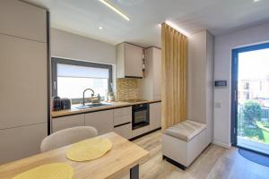 a kitchen with a dining table and a window at Casa Belsugului in Târgu-Mureş