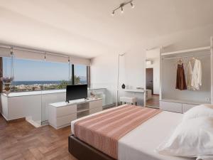 a bedroom with a bed with a television and a window at Villa Anemeli - Luxury pool villa with gorgeous seaview in Kissamos