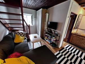 a living room with a couch and a stair case at White Rabbit Apartment in Spital am Semmering
