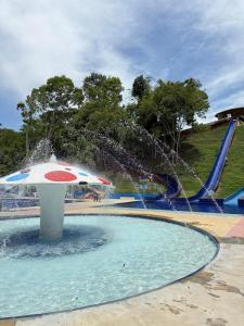 a water park with an umbrella and a water slide at Eco hotel el bosque in Doradal
