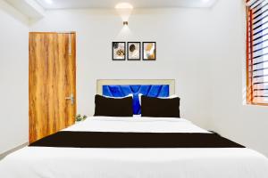 a bedroom with a white bed and a wooden door at Hotel O Blu Plaza in Gurgaon +22 photos