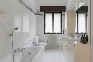 a bathroom with two sinks and a tub and a toilet at Casa dell'artista - Free Parking in Como