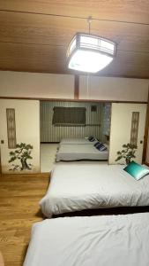 two beds in a room with a ceiling with a light at Sound Garden Biei - Forest suite in Biei