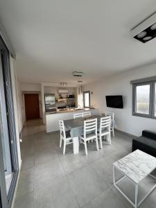 Una sala de estar con mesa y sillas y una cocina. en Torres al mar, en Monte Hermoso
