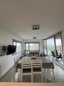 Un comedor con mesa y sillas y un televisor. en Torres al mar, en Monte Hermoso 8 fotos más