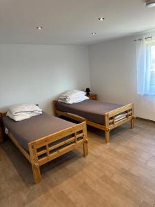 two twin beds in a room with a window at Traumhafte Ferienwohnung in Altendorf