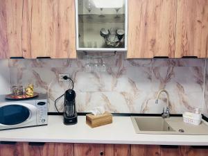 a kitchen counter with a microwave and a sink at Imperium DK Apartament in Giurgiu +39 photos