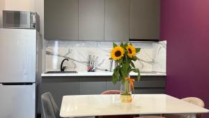 un jarrón de girasoles sentado en una mesa en una cocina en Sweet Home Deluxe Apart-Hotel, en Ereván