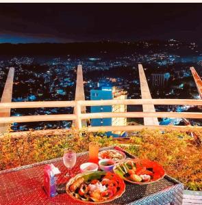 a table with two plates of food and wine glasses at City & Mountain View Condotel Near Ayala in Cebu City