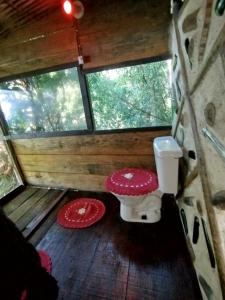 a small bathroom with a toilet and two windows at Filhas da Terra Jaguanum in Itacuruçá