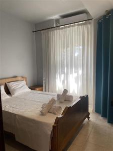 a bedroom with a bed with two pairs of shoes on it at Northern Comfort Apartment in Athens