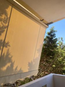 a side of a building with a tree in the background at Northern Comfort Apartment in Athens