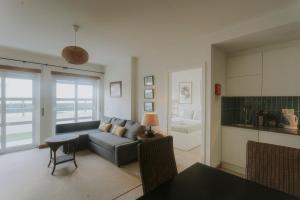 a living room with a couch and a table at Best Houses 40 - You me and the sea in Ferrel